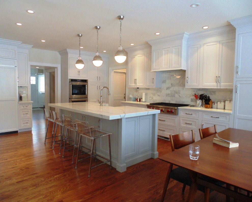 Eat-in kitchen - large transitional u-shaped medium tone wood floor and brown floor eat-in kitchen idea with a farmhouse sink, recessed-panel cabinets, white cabinets, quartz countertops, white backsplash, subway tile backsplash, stainless steel appliances, an island and white countertops