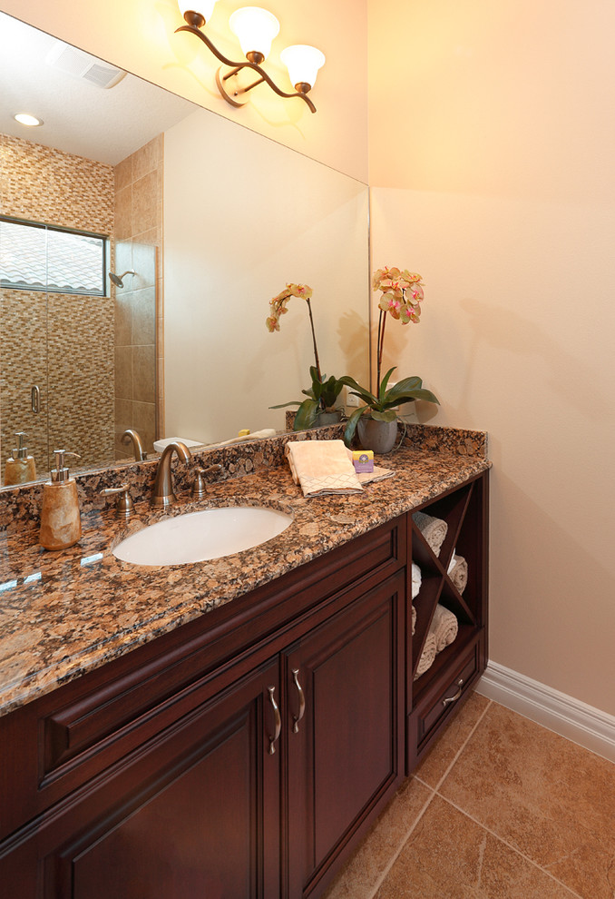 Inspiration for a mid-sized tropical 3/4 bathroom in Orlando with raised-panel cabinets, medium wood cabinets, beige walls, limestone floors, terrazzo benchtops and beige floor.