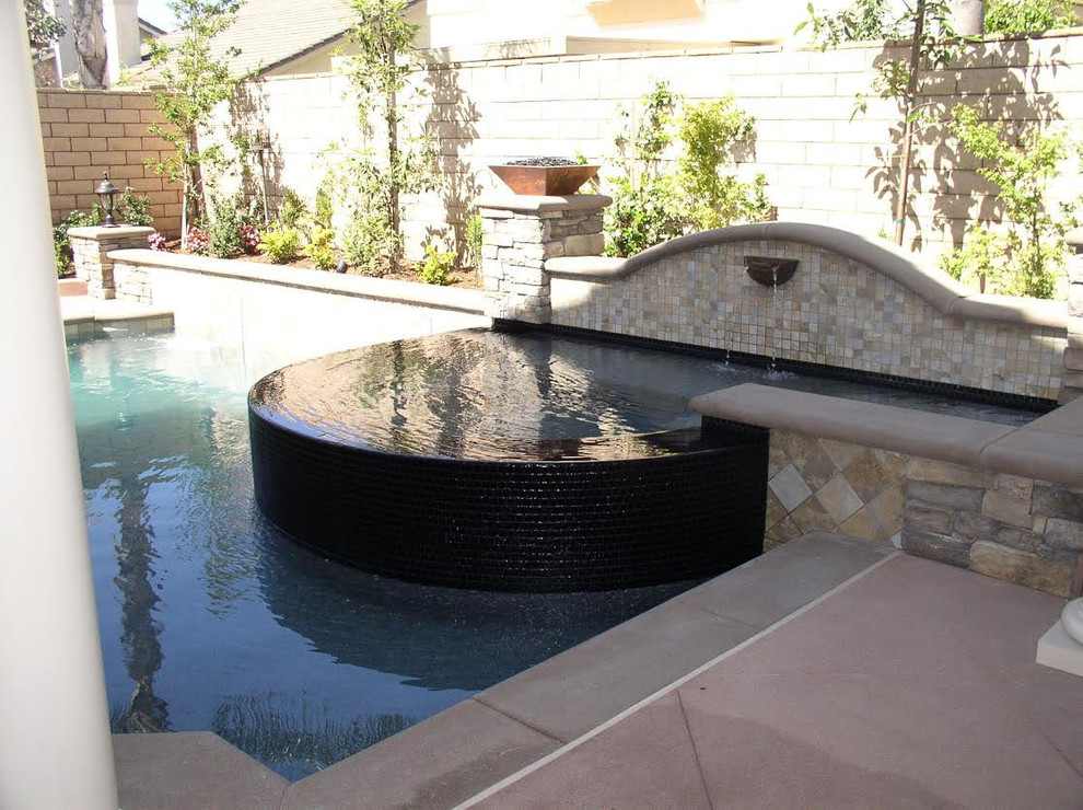 Mid-sized transitional backyard concrete paver and custom-shaped lap hot tub photo in Los Angeles