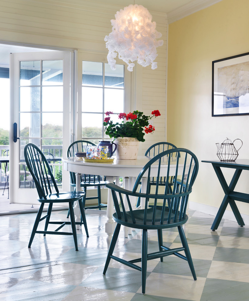 Beach style dining room in Providence with yellow walls and painted wood floors.