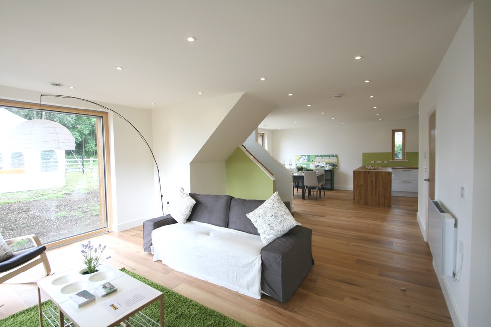Photo of a large modern open concept living room in Buckinghamshire with white walls, no fireplace and a freestanding tv.