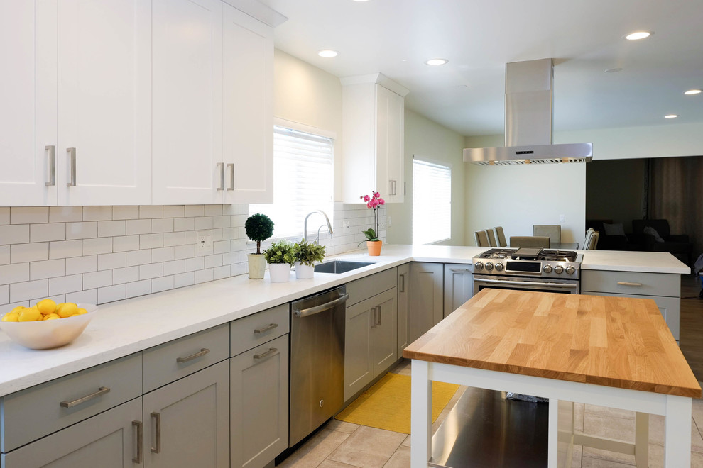 Large contemporary l-shaped eat-in kitchen in Los Angeles with a drop-in sink, shaker cabinets, white cabinets, quartz benchtops, white splashback, ceramic splashback, stainless steel appliances, ceramic floors, with island, pink floor and white benchtop.