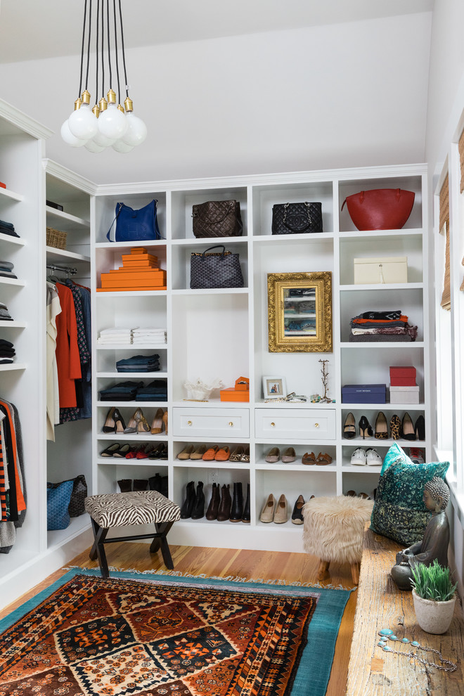 This is an example of a large eclectic gender-neutral walk-in wardrobe in Boston with shaker cabinets, white cabinets and medium hardwood floors.