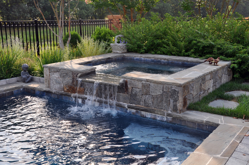 Inspiration for an expansive traditional backyard custom-shaped lap pool in DC Metro with a hot tub and natural stone pavers.
