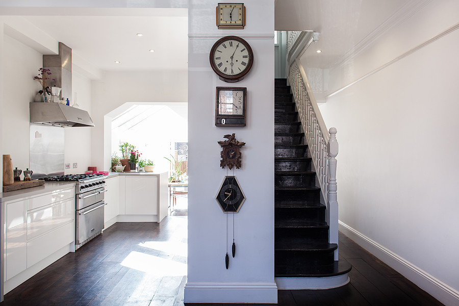 Mid-sized contemporary entry hall in London with white walls, dark hardwood floors, a single front door and a medium wood front door.