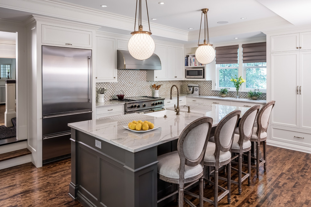 This is an example of a traditional l-shaped kitchen in Minneapolis with shaker cabinets, white cabinets, stainless steel appliances and with island.