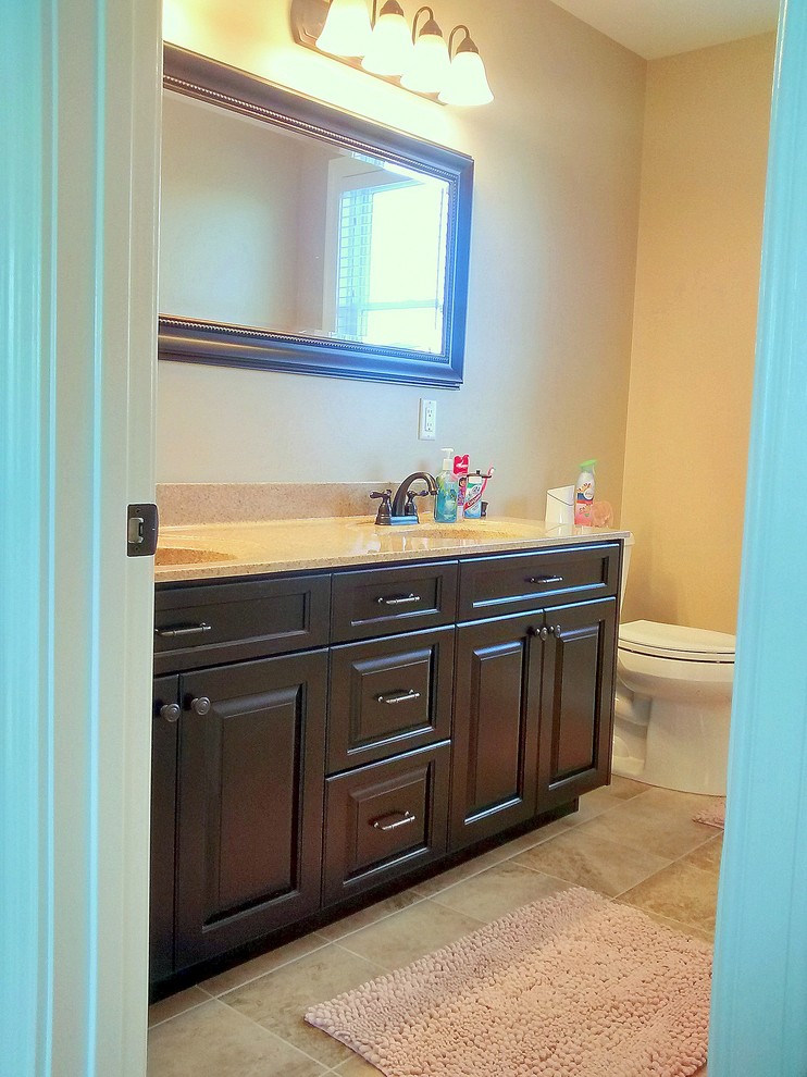 Inspiration for a mid-sized transitional kids' beige tile and ceramic tile ceramic tile bathroom remodel in Cincinnati with an integrated sink, raised-panel cabinets and dark wood cabinets