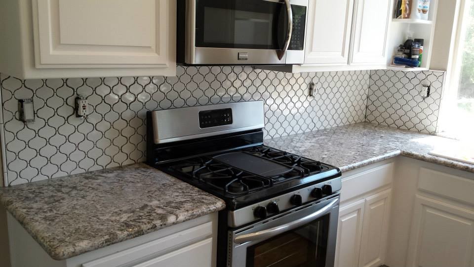 Inspiration for a small transitional l-shaped enclosed kitchen remodel in Sacramento with raised-panel cabinets, white cabinets, granite countertops, white backsplash, mosaic tile backsplash and stainless steel appliances