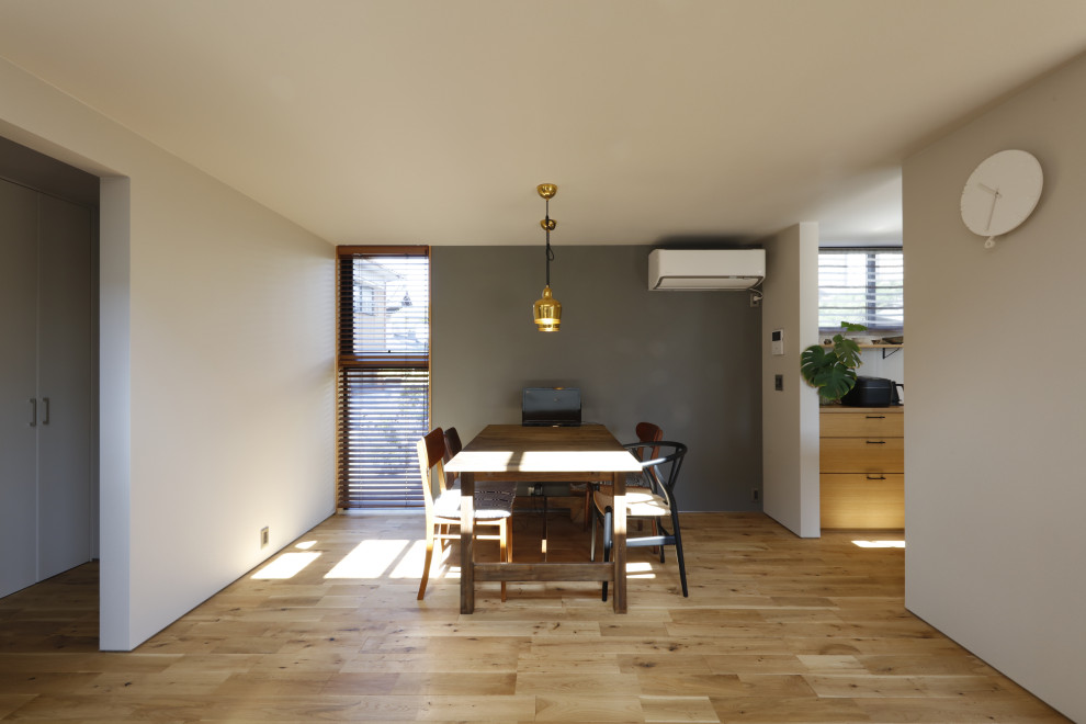 Пример оригинального дизайна: гостиная-столовая в стиле модернизм с серыми стенами, паркетным полом среднего тона, печью-буржуйкой, фасадом камина из плитки, коричневым полом, потолком с обоями и обоями на стенах