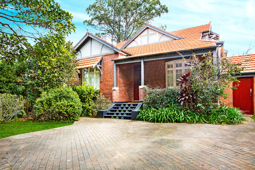 Inspiration for a traditional two-storey brick red house exterior in Sydney with a gable roof and a tile roof.