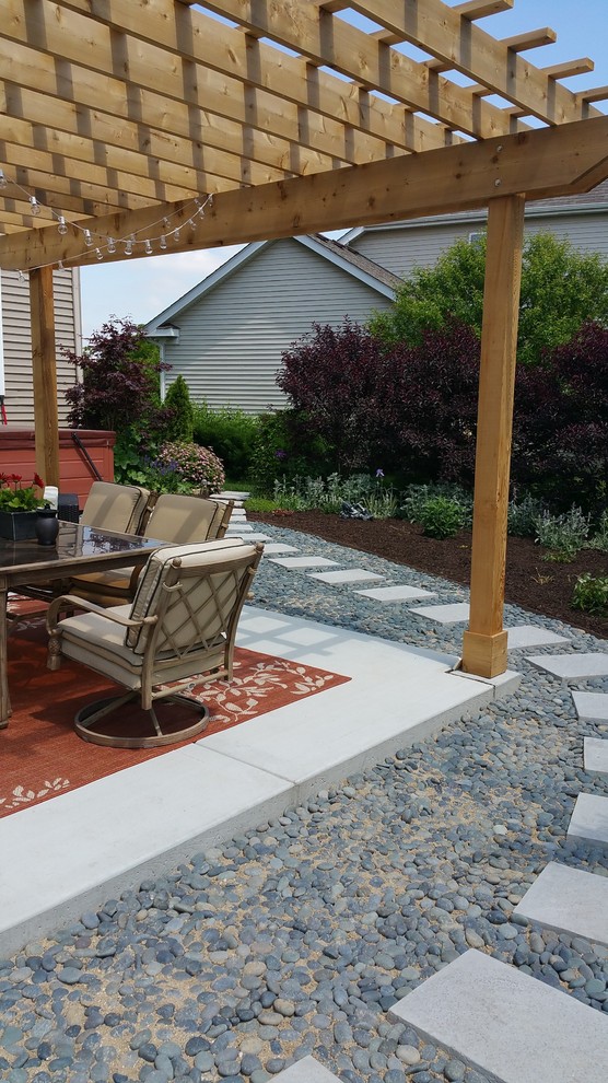 Design ideas for a mid-sized contemporary backyard patio in Chicago with a water feature, concrete slab and a pergola.