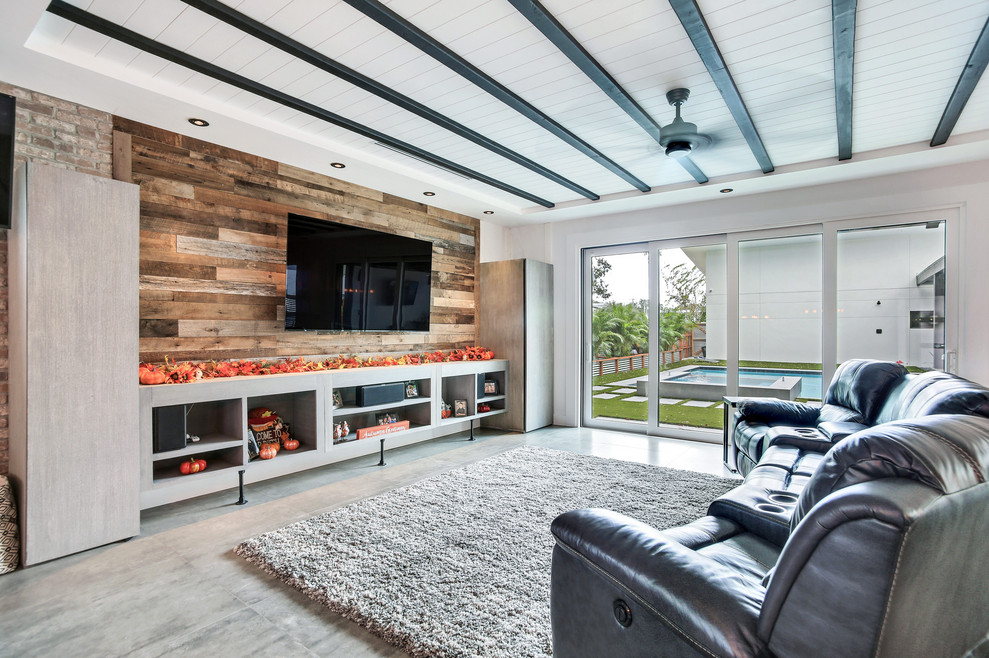 Photo of a mid-sized industrial formal open concept living room in Tampa with multi-coloured walls, a wall-mounted tv and grey floor.