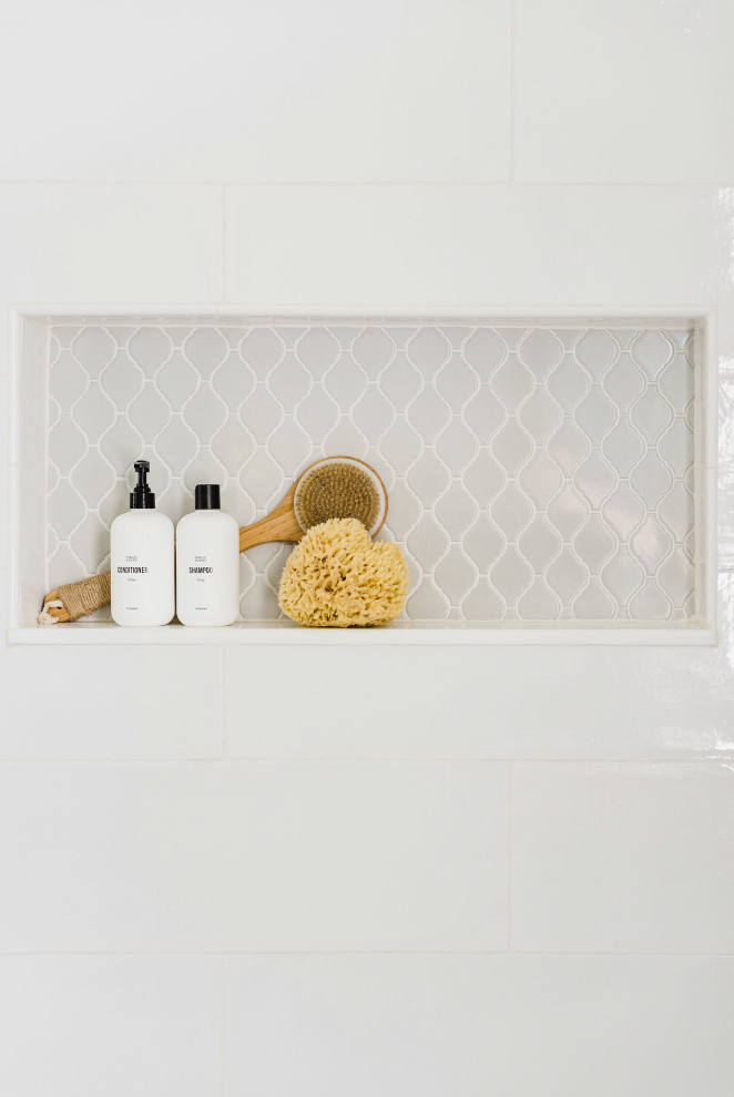 Cette image montre une salle de bain traditionnelle avec un carrelage blanc, des carreaux de porcelaine, un sol en carrelage de porcelaine, un sol blanc, une cabine de douche à porte battante et une niche.
