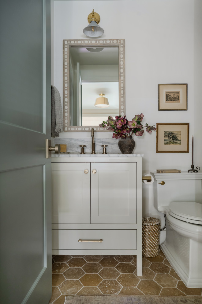 Kirkland New Construction - Transitional white tile beige floor and single-sink powder room photo in Seattle with shaker cabinets, white cabinets, a one-piece toilet, white walls, white countertops and a freestanding vanity