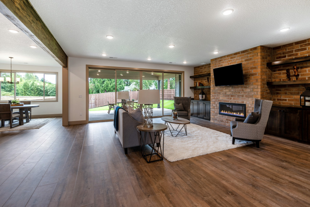 This is an example of a mid-sized traditional open concept living room in Portland with vinyl floors, a hanging fireplace, a brick fireplace surround, a wall-mounted tv and multi-coloured floor.