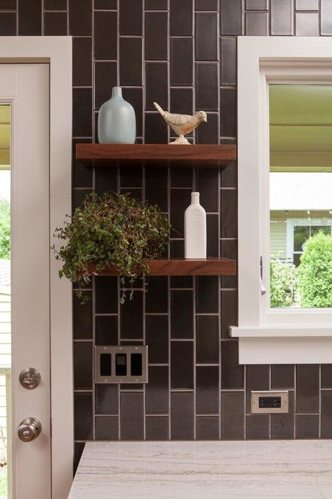 Midcentury separate kitchen in Portland with a farmhouse sink, flat-panel cabinets, dark wood cabinets, quartzite benchtops, black splashback, ceramic splashback and stainless steel appliances.