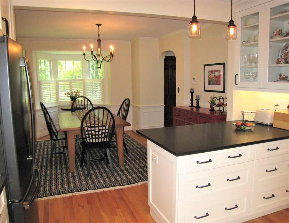 Example of a mid-sized transitional u-shaped light wood floor and beige floor kitchen design in Baltimore with an undermount sink, shaker cabinets, white cabinets, granite countertops, gray backsplash, a peninsula and gray countertops