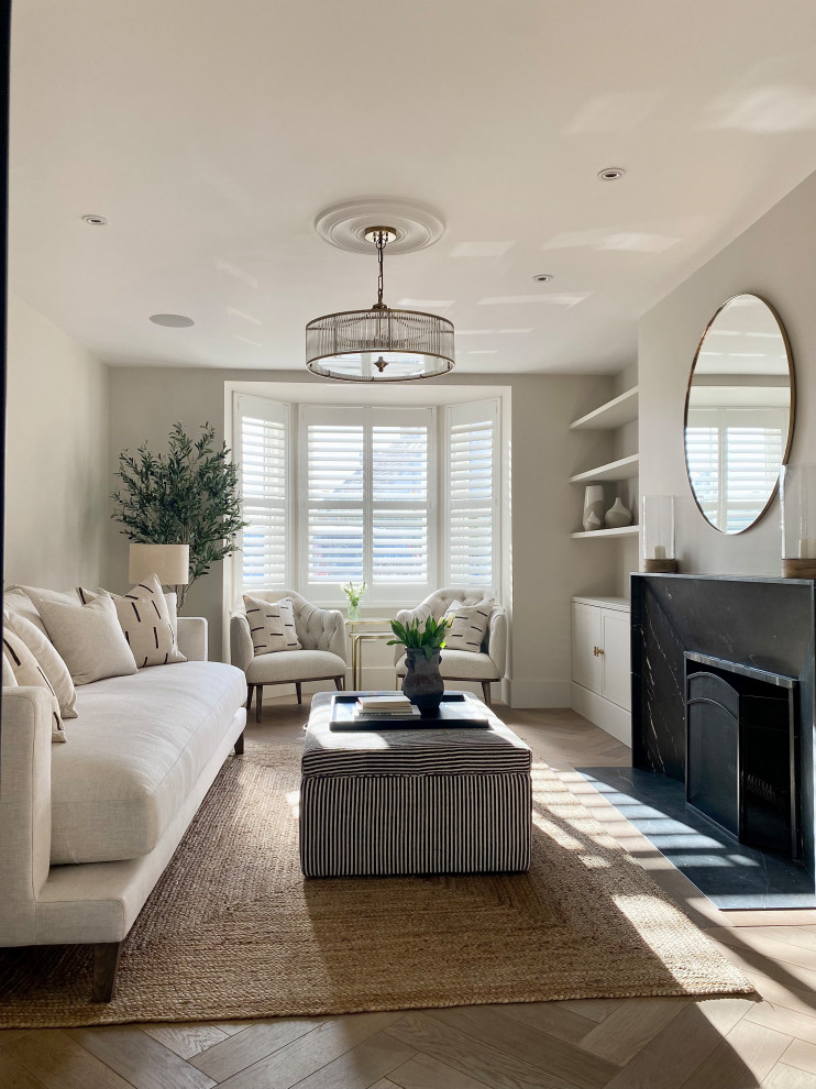 Inspiration for a traditional living room in Surrey with beige walls, light hardwood floors, a standard fireplace, a stone fireplace surround, a built-in media wall and brown floor.