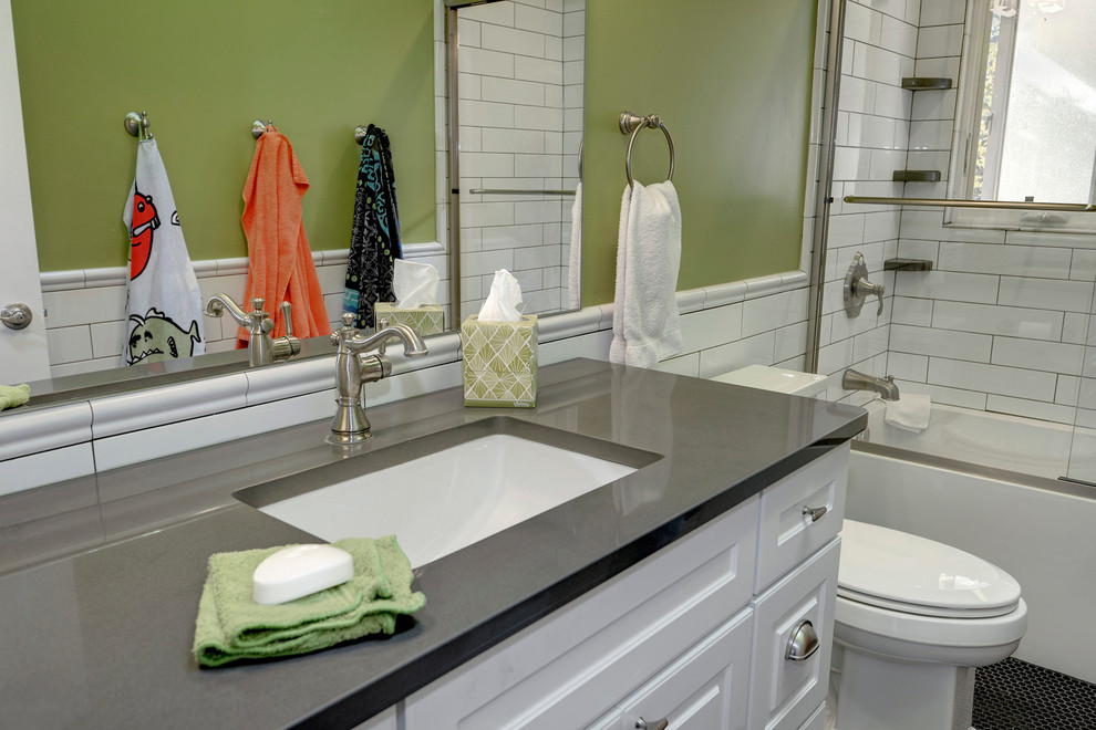 This is an example of a small contemporary kids bathroom in DC Metro with raised-panel cabinets, white cabinets, an alcove tub, a two-piece toilet, white tile, ceramic tile, green walls, mosaic tile floors, an undermount sink, engineered quartz benchtops and a shower/bathtub combo.