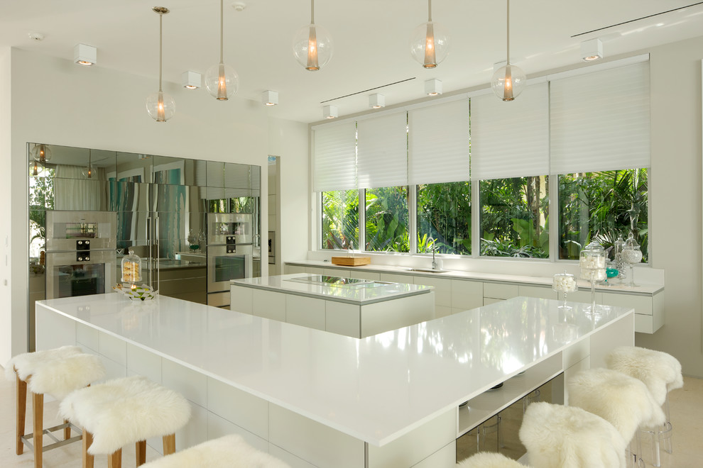 Large contemporary u-shaped open plan kitchen in Miami with an undermount sink, flat-panel cabinets, white cabinets, multiple islands, quartz benchtops, panelled appliances and ceramic floors.