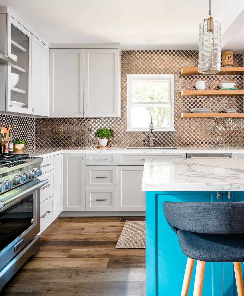 Inspiration for a mid-sized transitional l-shaped eat-in kitchen in Houston with an undermount sink, shaker cabinets, grey cabinets, metallic splashback, metal splashback, stainless steel appliances, porcelain floors, with island, multi-coloured floor and white benchtop.