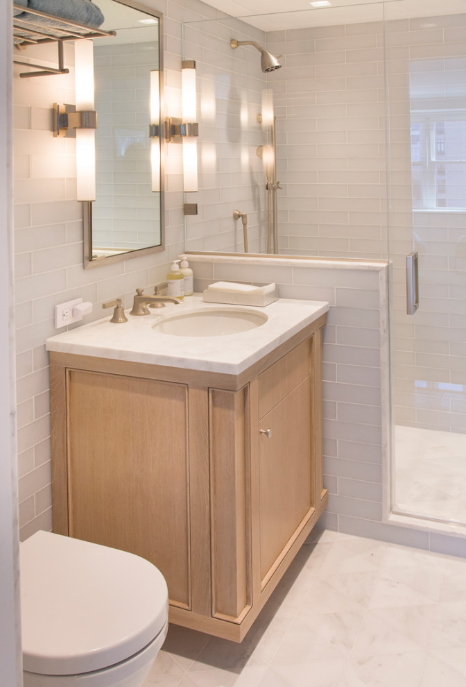 This is an example of a small modern master wet room bathroom in New York with raised-panel cabinets, white cabinets, a one-piece toilet, white tile, ceramic tile, white walls, ceramic floors, a drop-in sink, engineered quartz benchtops, white floor, a sliding shower screen, white benchtops, an enclosed toilet, a double vanity and a built-in vanity.