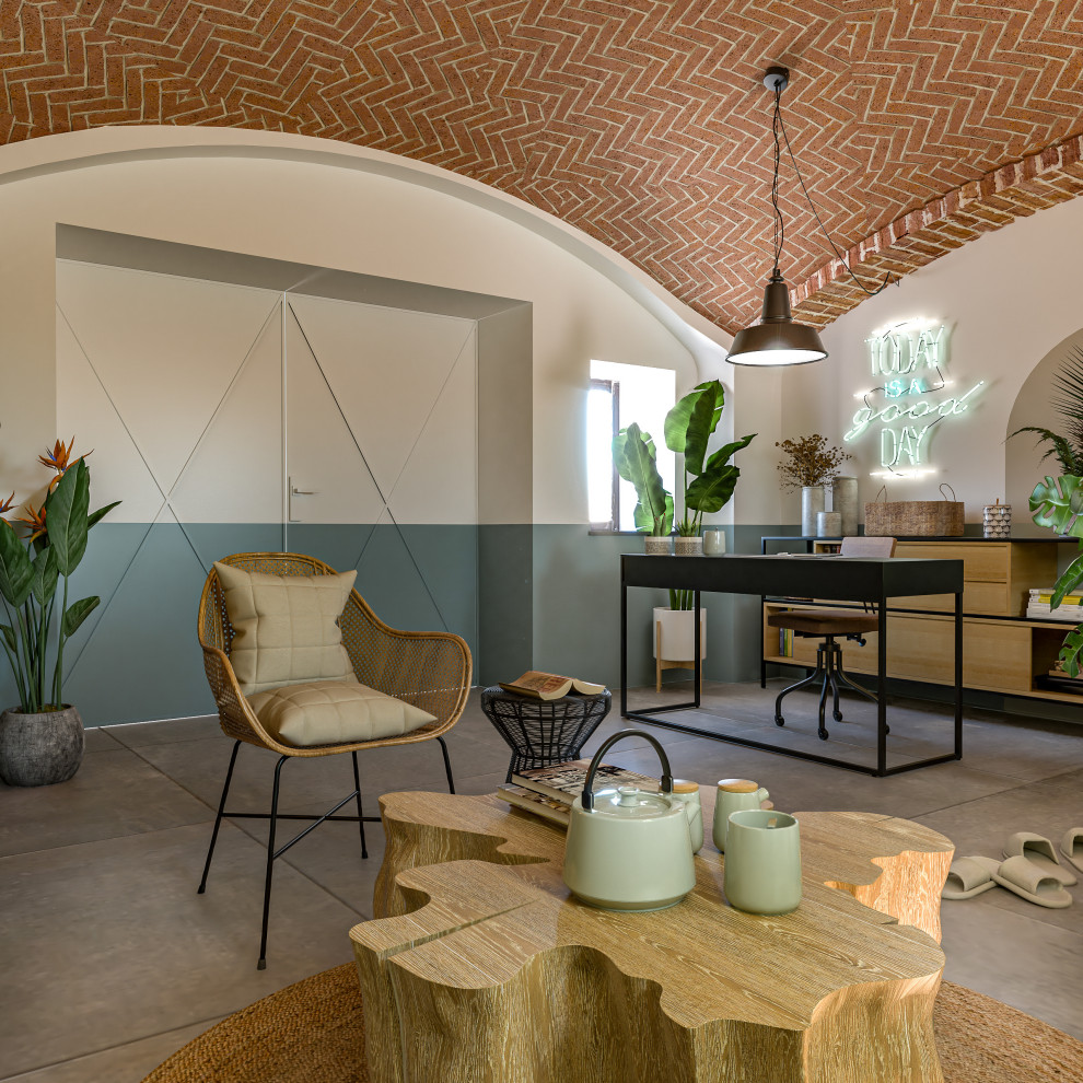 Photo of a medium sized urban walk-out basement in Milan with multi-coloured walls, porcelain flooring, a wood burning stove, a metal fireplace surround, grey floors and a vaulted ceiling.
