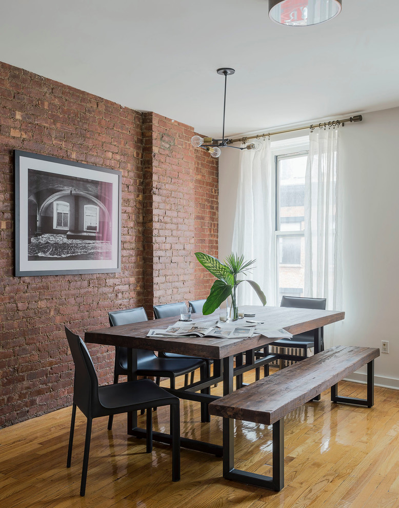 This is an example of a mid-sized industrial kitchen/dining combo in New York with white walls and medium hardwood floors.