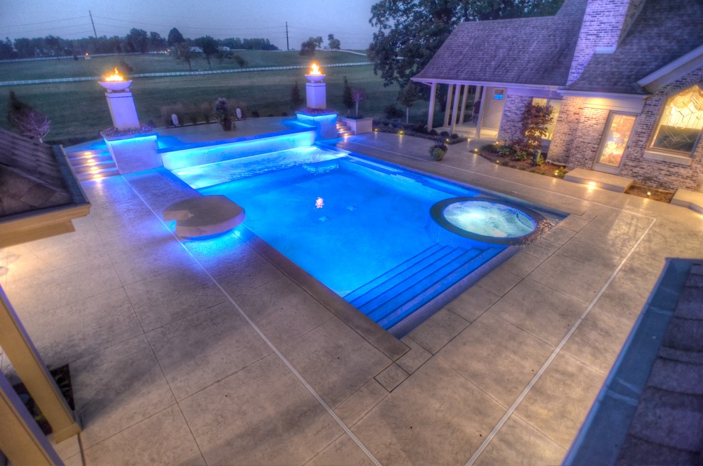 Example of a large transitional backyard concrete paver and rectangular natural hot tub design in Cedar Rapids