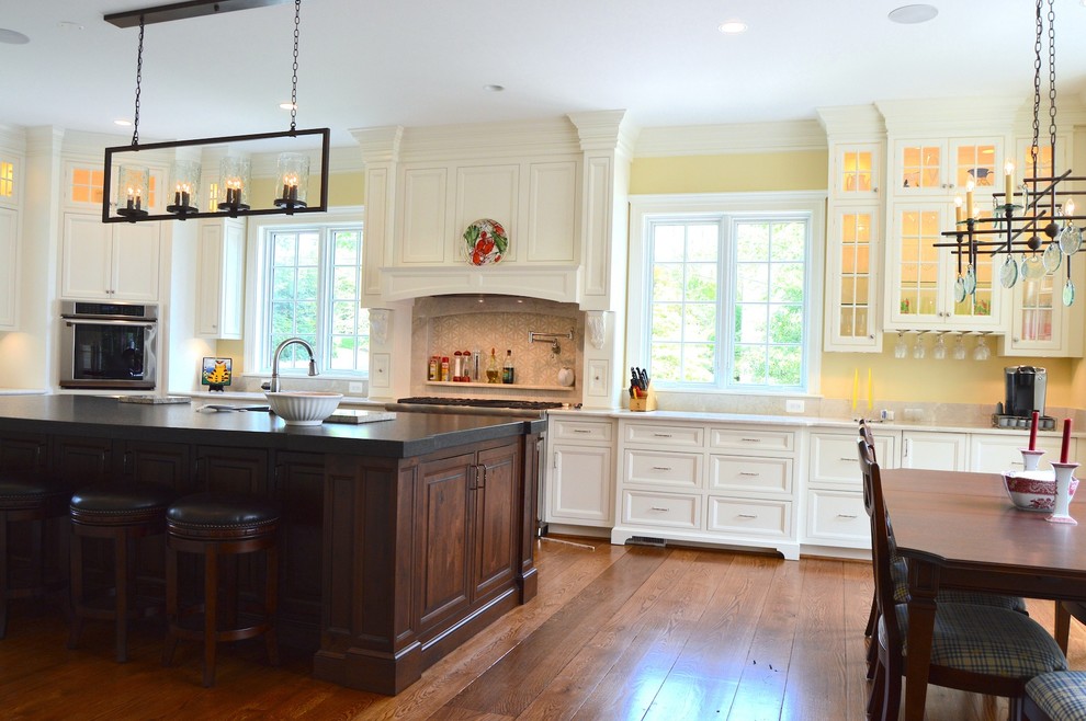 Photo of an expansive traditional l-shaped eat-in kitchen in DC Metro with a farmhouse sink, beaded inset cabinets, white cabinets, marble benchtops, beige splashback, ceramic splashback, panelled appliances, medium hardwood floors and with island.