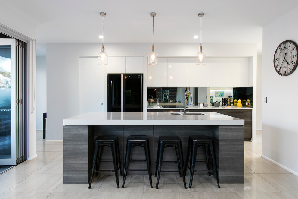 Photo of a contemporary galley kitchen in Brisbane with an undermount sink, flat-panel cabinets, dark wood cabinets, mirror splashback, stainless steel appliances and with island.