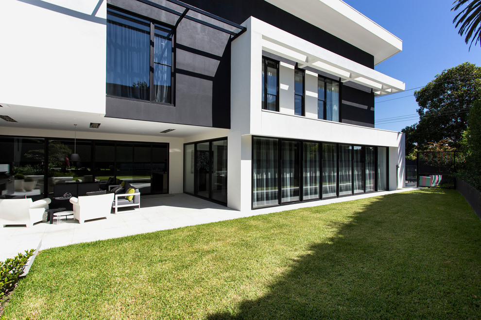 Photo of a large contemporary two-storey black house exterior in Melbourne.