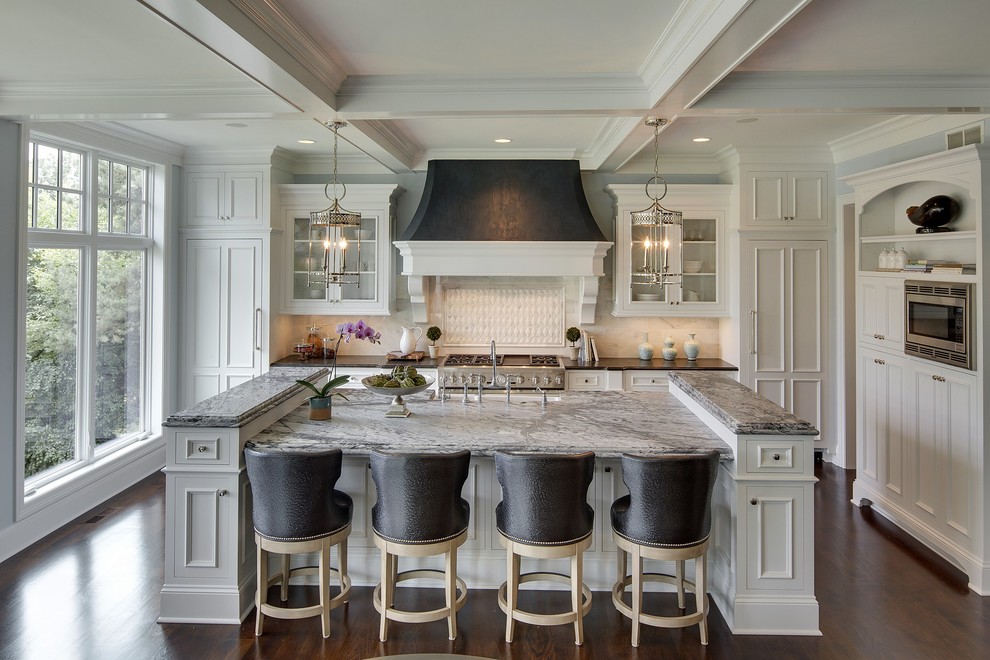 Inspiration for a traditional l-shaped kitchen in Minneapolis with an undermount sink, recessed-panel cabinets, white cabinets, white splashback, stainless steel appliances, dark hardwood floors, with island and marble benchtops.