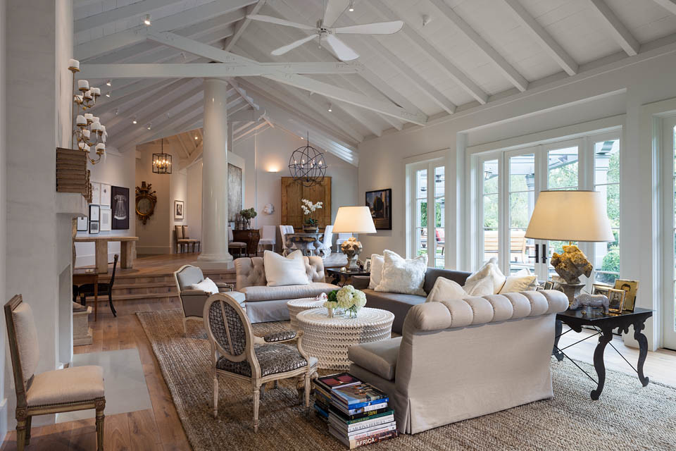 Photo of a large beach style formal enclosed living room in San Francisco with white walls, medium hardwood floors, a standard fireplace, a concrete fireplace surround, no tv and brown floor.