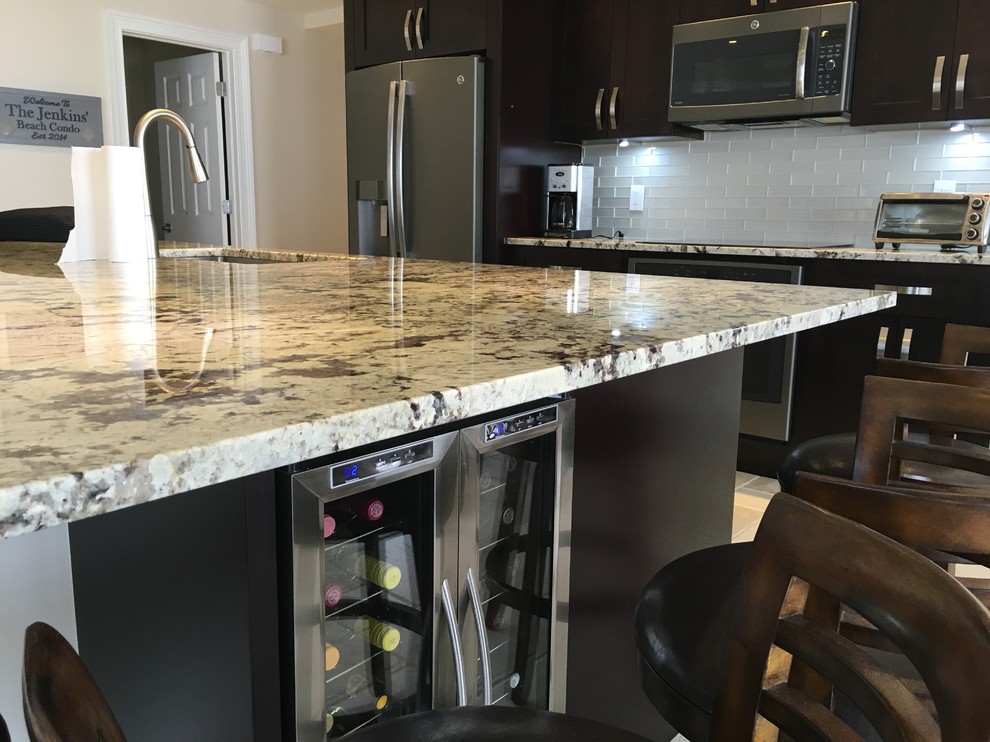 Kitchen - mid-sized transitional beige floor kitchen idea in Miami with an undermount sink, shaker cabinets, dark wood cabinets, gray backsplash, stainless steel appliances and an island