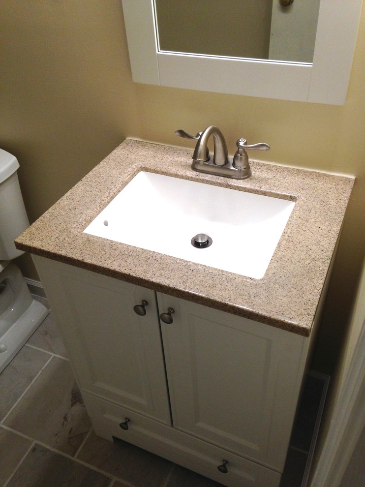 Example of a small transitional 3/4 white tile and porcelain tile porcelain tile alcove bathtub design with an integrated sink, flat-panel cabinets, white cabinets, solid surface countertops, a one-piece toilet and beige walls