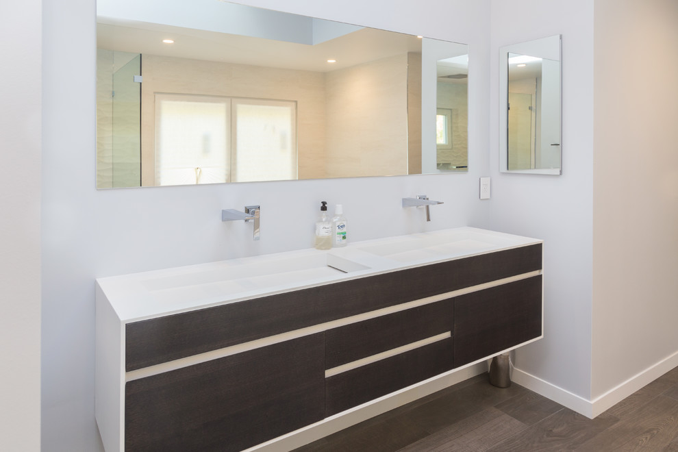 This is an example of a mid-sized modern master bathroom in San Francisco with flat-panel cabinets, light wood cabinets, grey walls, medium hardwood floors and an integrated sink.