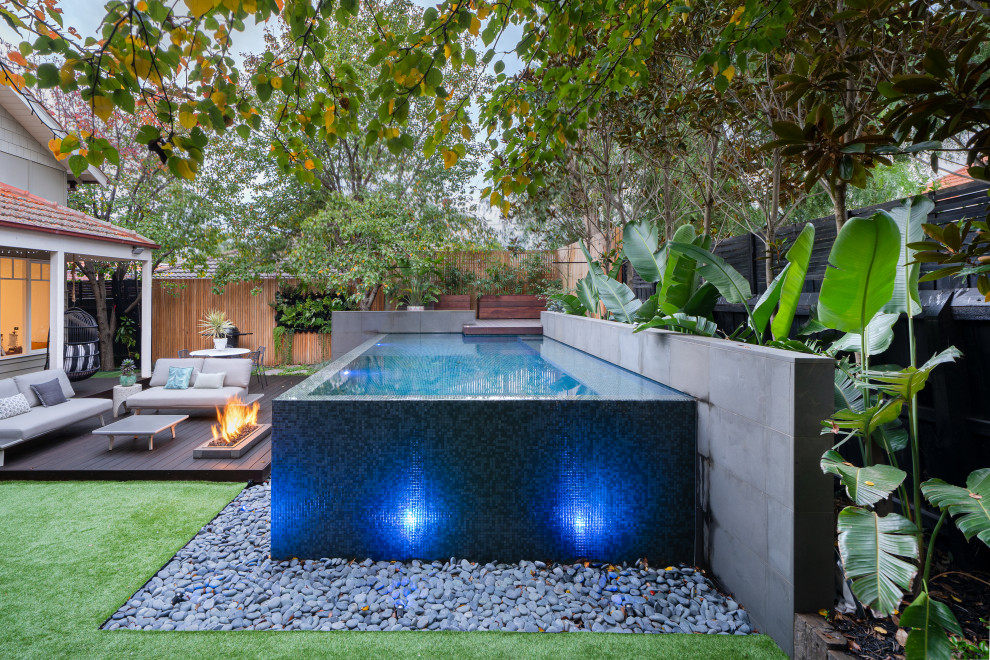 Small tropical backyard rectangular infinity pool in Melbourne with with a pool.