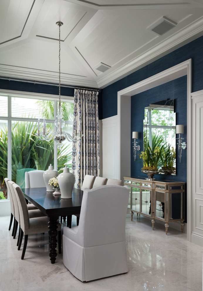 This is an example of a beach style dining room in Miami with blue walls and beige floor.