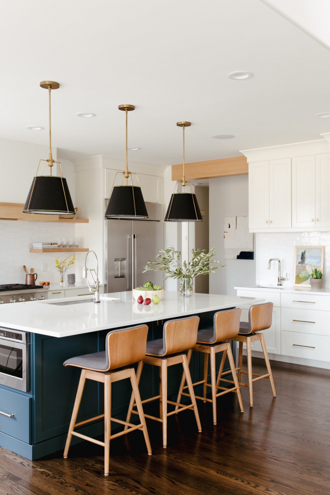 Design ideas for a large contemporary u-shaped open plan kitchen in Denver with an undermount sink, shaker cabinets, white cabinets, white splashback, stainless steel appliances, dark hardwood floors, with island, brown floor and white benchtop.