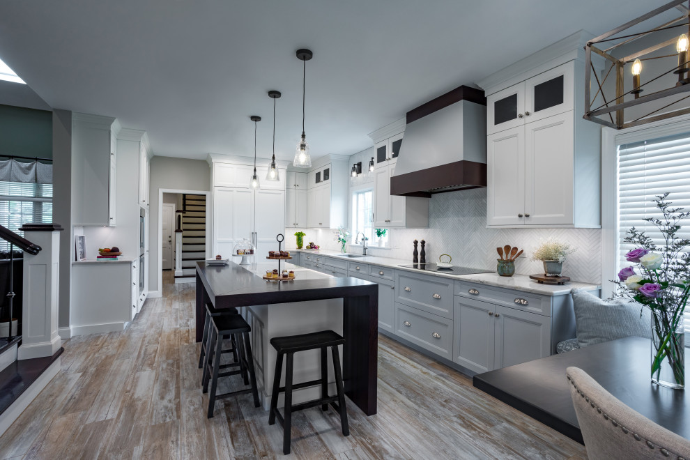 Inspiration for a large country l-shaped enclosed kitchen in Other with a submerged sink, shaker cabinets, white cabinets, quartz worktops, white splashback, marble splashback, integrated appliances, porcelain flooring, an island, brown floors and white worktops.