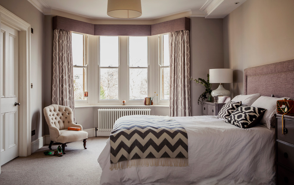 Inspiration for a mid-sized transitional master bedroom in Hampshire with grey walls and carpet.