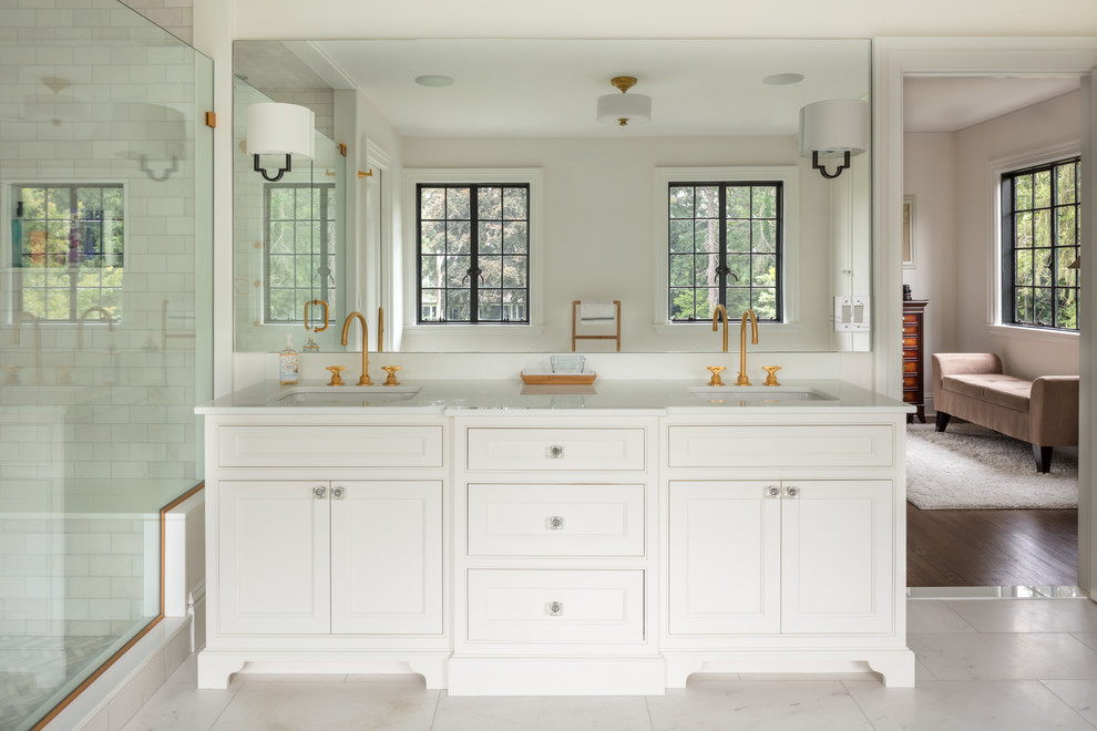 Traditional master bathroom in New York with beaded inset cabinets, light wood cabinets, an alcove shower, white tile, subway tile, white walls, an undermount sink and white floor.
