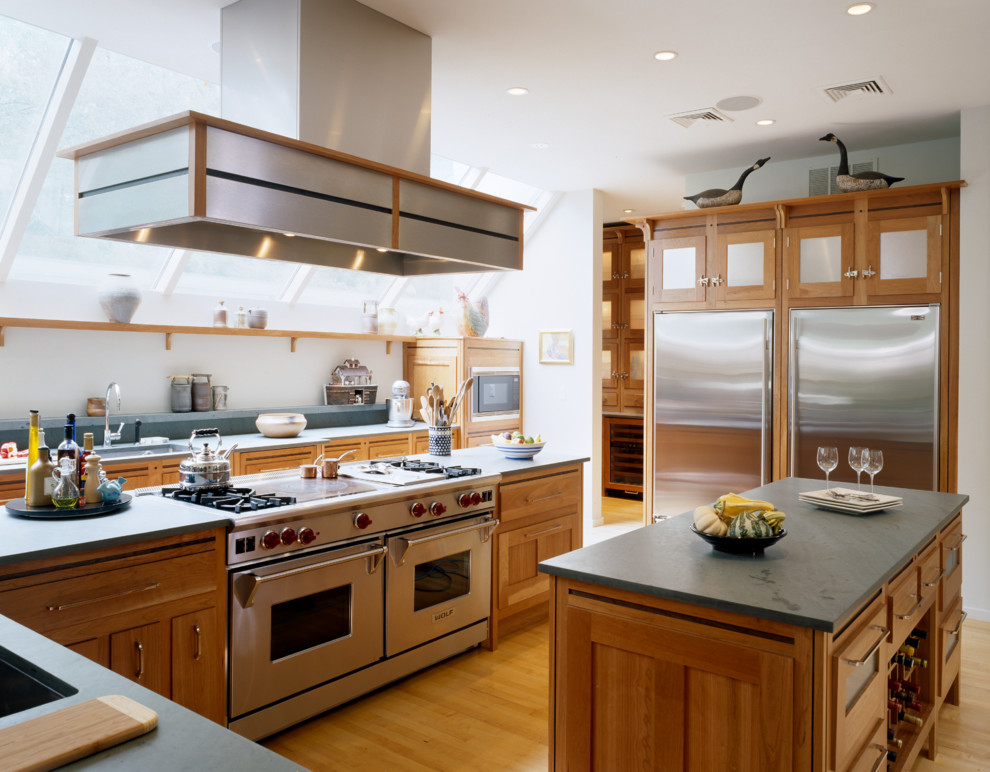 This is an example of a transitional kitchen in Boston with an undermount sink, shaker cabinets, medium wood cabinets, stainless steel appliances and medium hardwood floors.