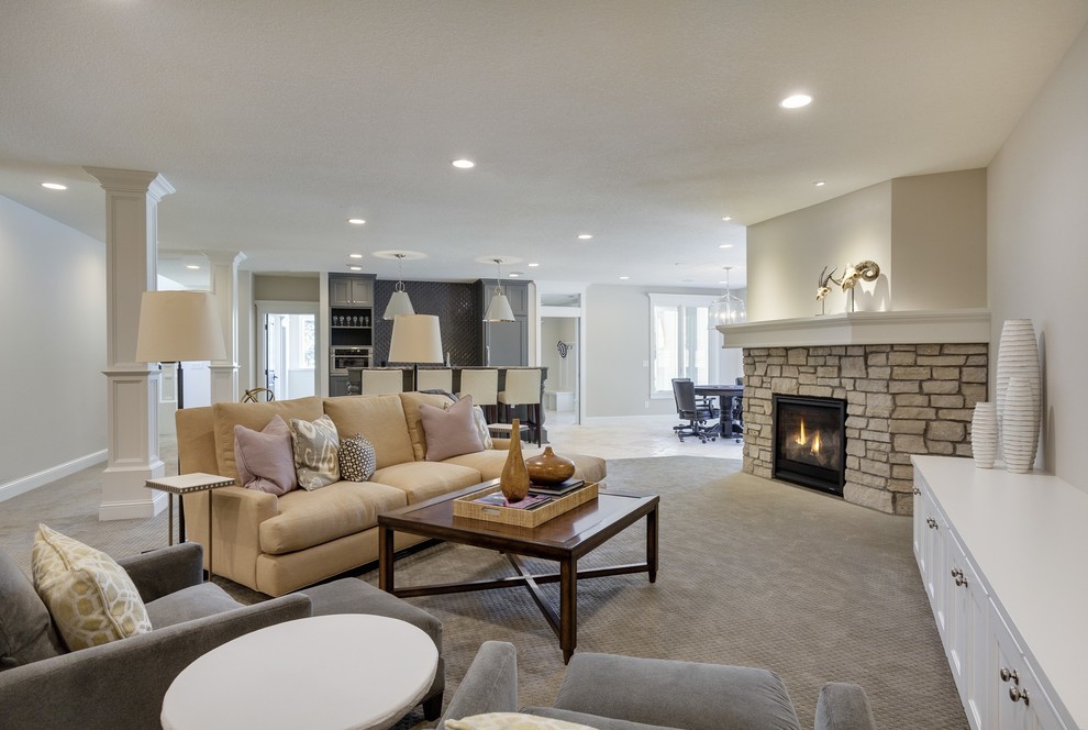 Design ideas for a traditional walk-out basement in Minneapolis with beige walls, carpet, a standard fireplace, a stone fireplace surround and grey floor.