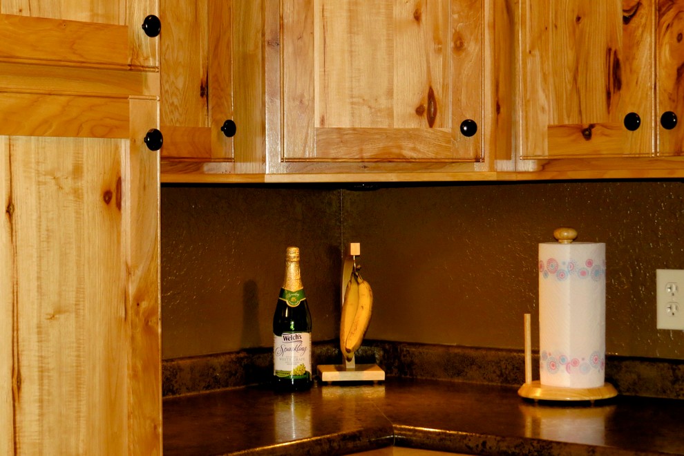 Enclosed kitchen - mid-sized rustic u-shaped medium tone wood floor and brown floor enclosed kitchen idea with a double-bowl sink, shaker cabinets, medium tone wood cabinets, black appliances and no island