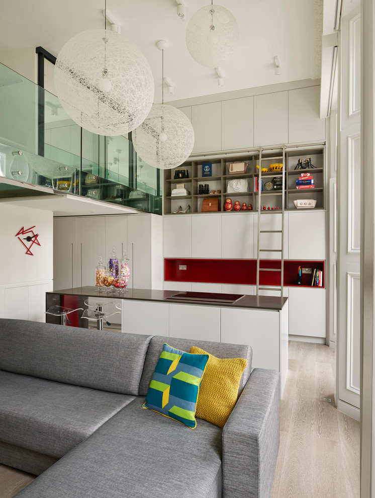 ロンドンのコンテンポラリースタイルのおしゃれなキッチン (フラットパネル扉のキャビネット、珪岩カウンター、淡色無垢フローリング、白いキャビネット、赤いキッチンパネル) の写真