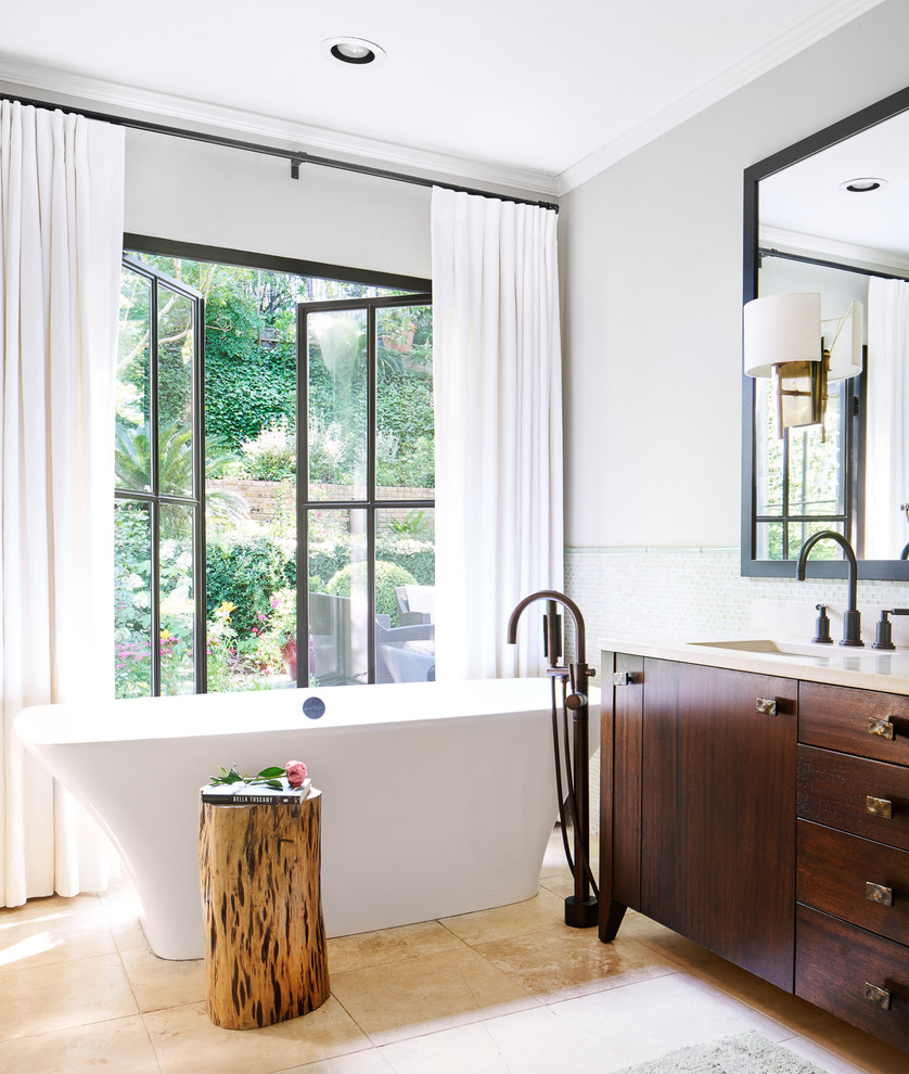 Freestanding bathtub - transitional master green tile and glass tile limestone floor freestanding bathtub idea in Austin with dark wood cabinets, a drop-in sink, limestone countertops and flat-panel cabinets