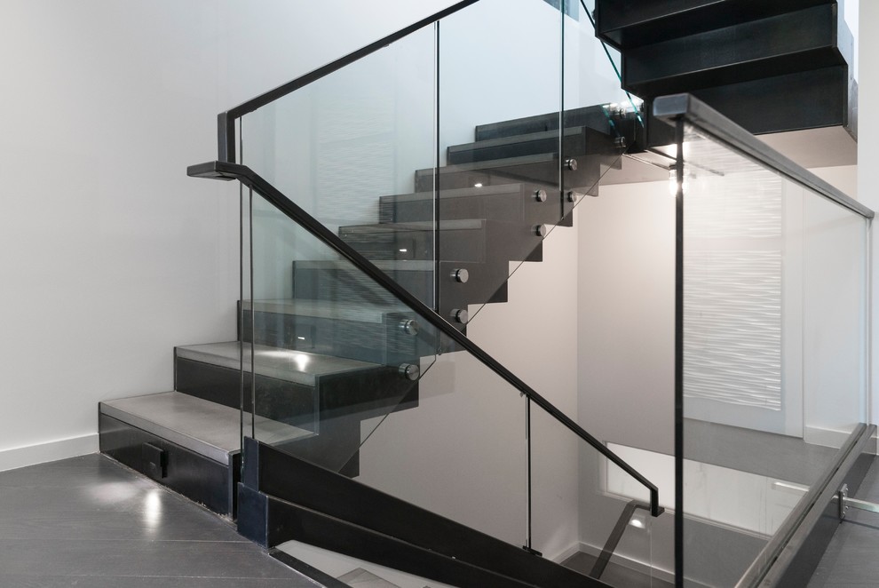 Design ideas for a mid-sized contemporary concrete u-shaped staircase in Salt Lake City with metal risers and glass railing.