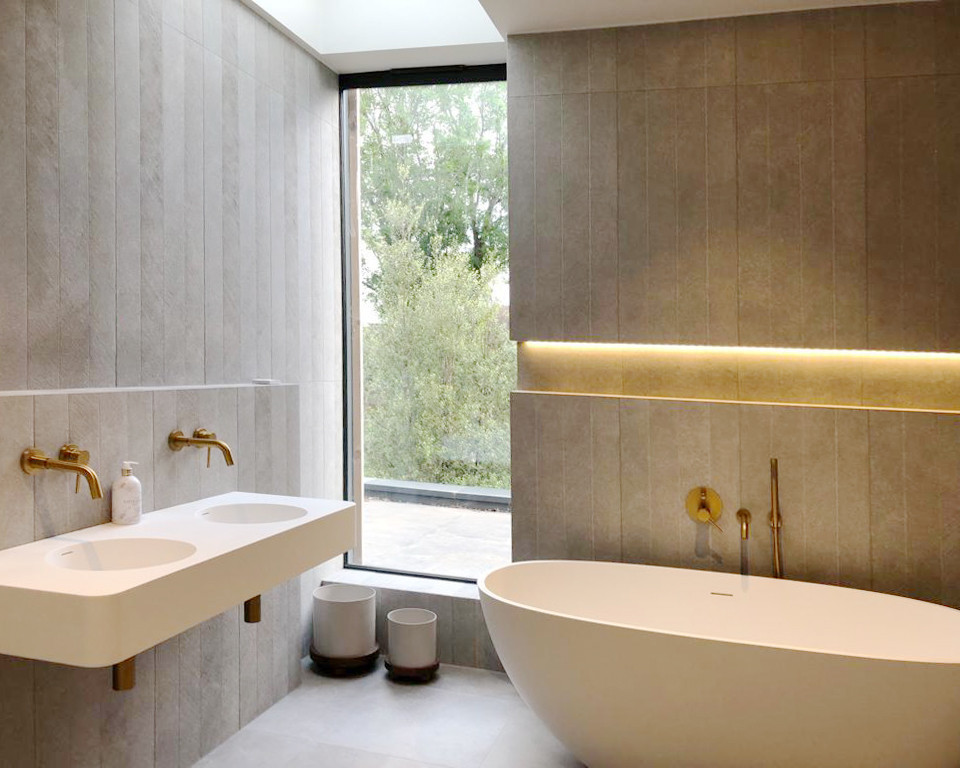 Inspiration for a contemporary grey and white family bathroom in London with open cabinets, a freestanding bath, a wall mounted toilet, grey tiles, slate tiles, grey walls, porcelain flooring, a wall-mounted sink, grey floors, white worktops, a wall niche, double sinks and a floating vanity unit.
